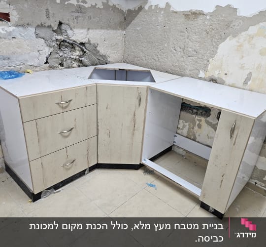 ארונות מטבח בפינת חדר עם קיר חשוף